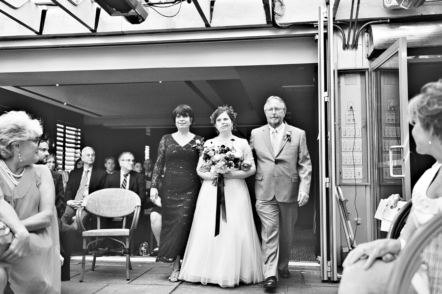 bride walking down the aisle with both parents